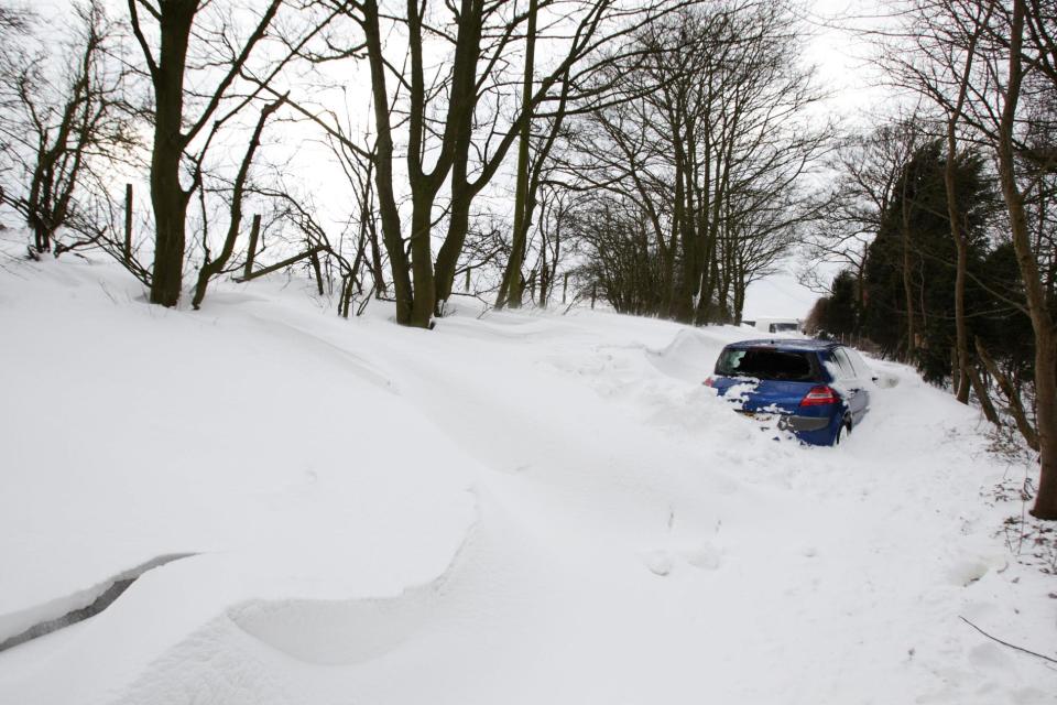 A stranded vehicle near Barr Beacon in the West Midlands is almost covered by snow (SWNS)