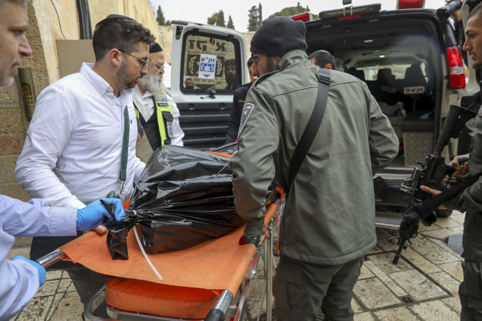 Israeli security personnel and members of Zaka Rescue and Recovery team carry the body of a Palestinian man who was fatally shot by Israeli police after he killed one Israeli and wounded four others in a shooting attack in Jerusalem's Old City, Sunday, Nov. 21, 2021. (AP Photo/Mahmoud Illean)