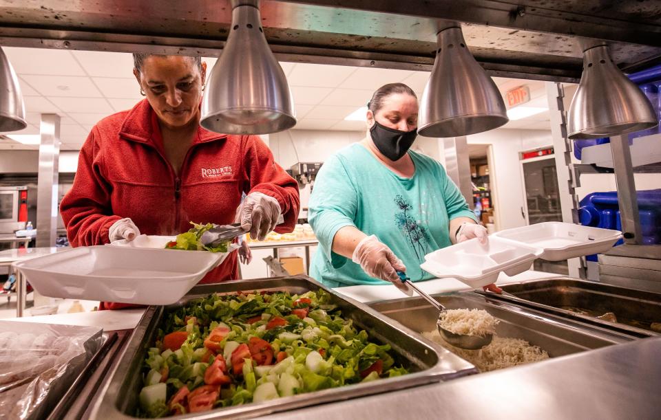 Juliet Mugica, left, and Patricia Lane, right, prepare the meal on May 11 at the dining hall of the Salvation Army Center of Hope.