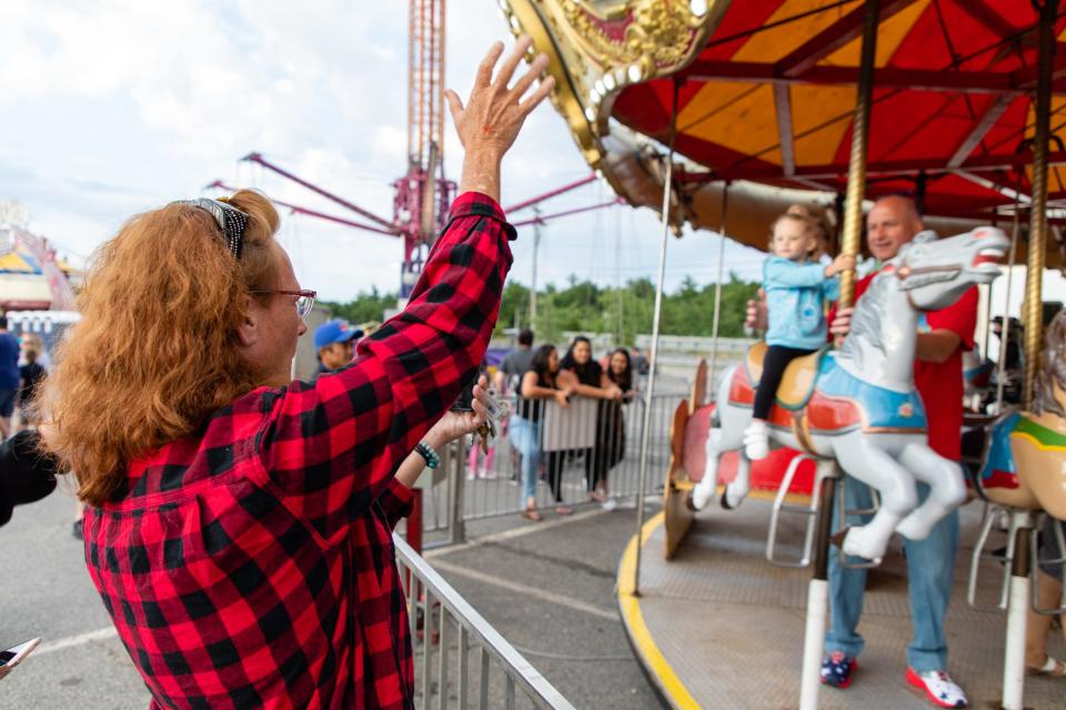 Kristin Sylvester, left, of Plymouth, waves to her niece, Addaline, 2, who is accompanied by her father, Ron Sylvester, of Plymouth, at the carousel during the Kingston Carnival on Saturday, June 10.