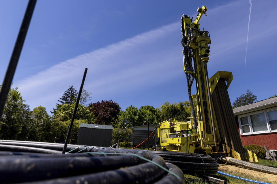 Flexible piping is coiled near a drill rig outside a home in White Plains, N.Y., Monday, May 8, 2023. A water-filled loop installed several hundred feet deep is used to either carry heat away from or into the house, depending on the season. Industry experts see the technology becoming increasingly popular in the coming years. (AP Photo/Julia Nikhinson)