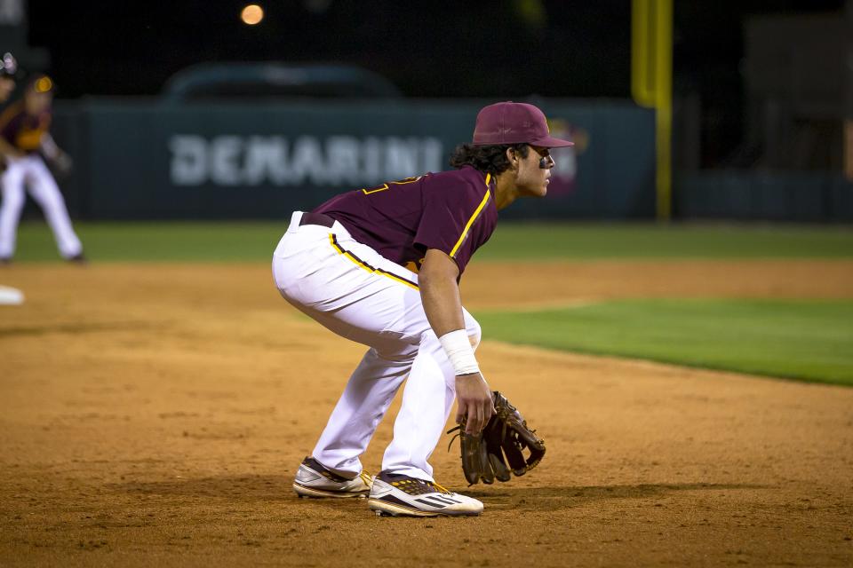ASU's Nate Baez (12) hunches as he watches the UNLV batter during a home game against UNLV held at Phoenix Municipal Stadium on Apr. 26, 2022.