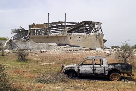 A damaged vehicle is seen in front of a destroyed building at Qarmeed camp, after Islamist rebel fighters took control of the area from forces of Syria's President Bashar al-Assad, April 27, 2015. REUTERS/Ammar Abdullah