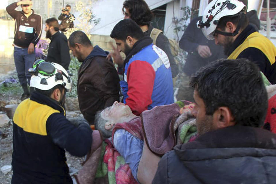 This photo released by the opposition Syrian Civil Defense rescue group, also known as White Helmets, which has been authenticated based on its contents and other AP reporting, shows Civil Defense workers evacuate a victim from site of airstrikes in the village of Balyoun, in Idlib province, Syria, Saturday, Dec. 7, 2019. Airstrikes on areas in the last major rebel stronghold in northwest Syria on Saturday killed at least 18 people, including women and children, and wounded others as a three-month truce crumbles, opposition activists said. (Syrian Civil Defense White Helmets via AP)