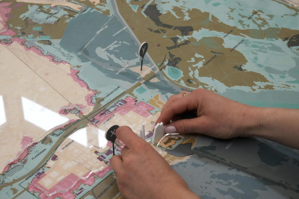 A woman sets an installation part of "Coastal Imaginaries" at the Denmark pavilion, at the Biennale International Architecture exhibition, in Venice, Italy, Wednesday, May 17, 2023. The 18th edition of the Biennale International Architecture exhibition will open to the public from Saturday May 20 to Sunday Nov. 26, 2023. (AP Photo/Antonio Calanni)