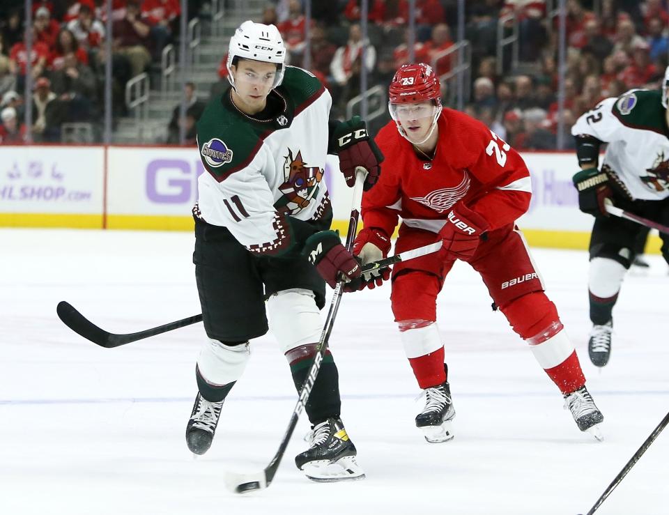 Arizona Coyotes right wing Dylan Guenther (11) shoots while pursued by Detroit Red Wings left wing Lucas Raymond (23) during the second period of an NHL hockey game Friday, Nov. 25, 2022, in Detroit. (AP Photo/Duane Burleson)