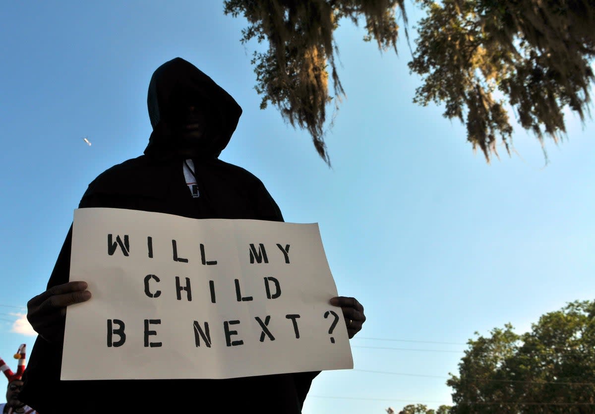 A man dressed in a hood holds up a sign saying "Will My Child Be Next?", during a protest march in Sanford, Florida following the 2012 killing of Trayvon Martin  (Getty Images)