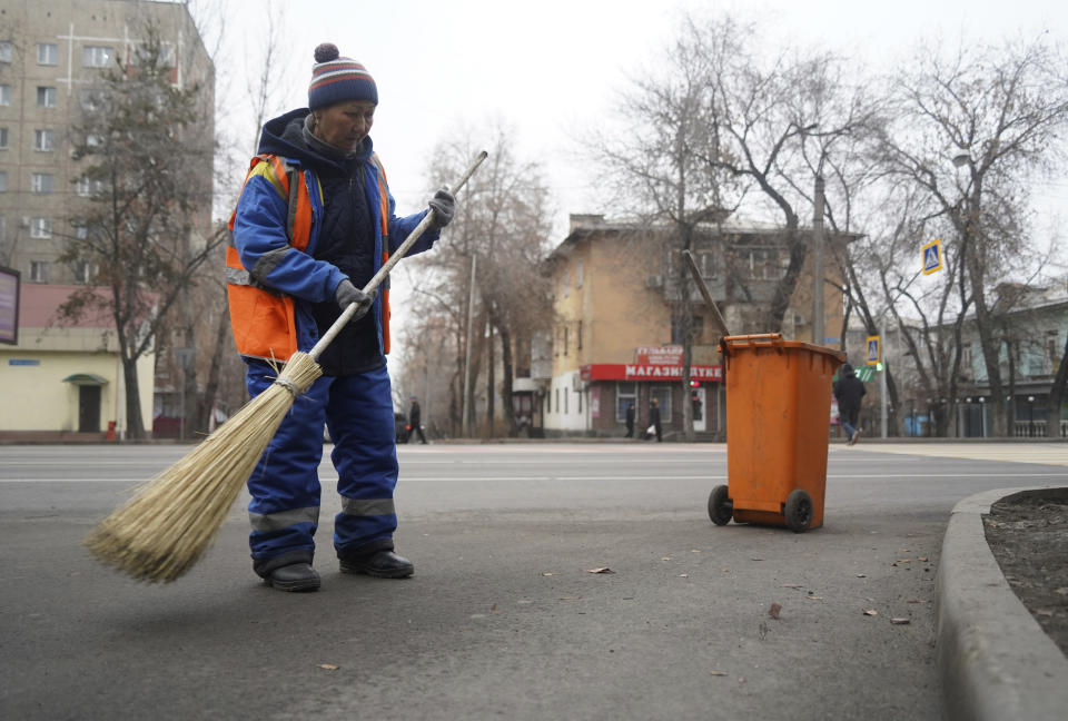A municipal worker sweeps the street in Almaty, Kazakhstan, Monday, Jan. 10, 2022. Kazakhstan's health ministry says over 160 people have been killed in protests that have rocked the country over the past week. President Kassym-Jomart Tokayev's office said Sunday that order has stabilized in the country and that authorities have regained control of administrative buildings that were occupied by protesters, some of which were set on fire. (Vladimir Tretyakov/NUR.KZ via AP)