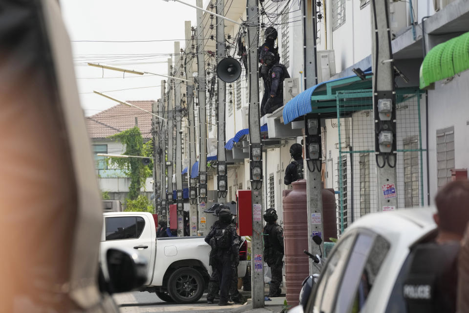 Members of the Thai armed commando police are seen outside a home of a senior police officer in Bangkok, Thailand, Wednesday, March 15, 2023. Thai police on Wednesday detained the senior police officer who fired multiple gunshots from his home in Bangkok, ending a standoff of over 24 hours after his colleagues tried to take him to be treated for mental illness. (AP Photo/Sakchai Lalit)