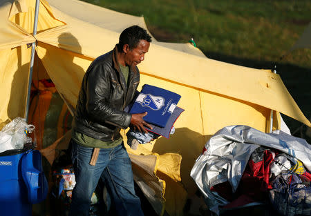 A Venezuelan migrant carries his belongings out of a tent inside a temporary humanitarian camp that is closed by the government, in Bogota, Colombia January 15, 2019. REUTERS/Luisa Gonzalez