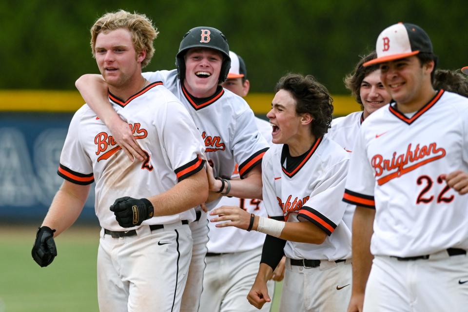 Brighton's Jack Storey, left, celebrates with teammates after beating Howell to win the Division 1 baseball district title on Saturday, June 4, 2022, at East Lansing High School.