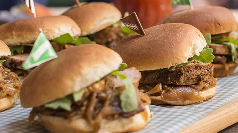 A group of pork sliders with toothpick garnishes