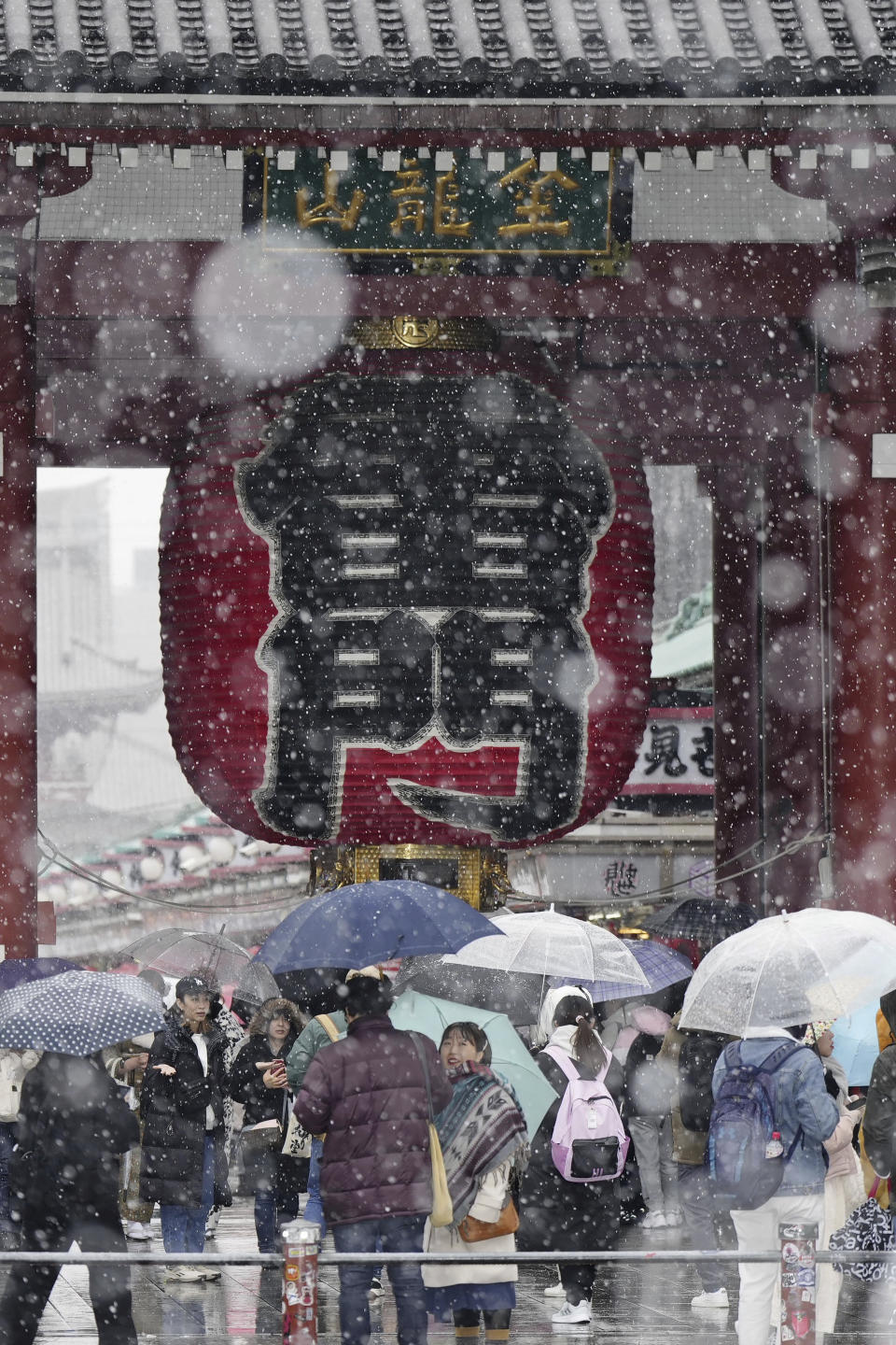 People visit Sensoji temple at the Asakusa district in Tokyo in snow Monday, Feb. 5, 2024. (Kyodo News via AP)