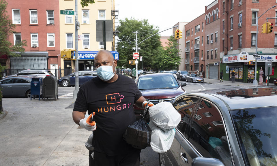 Driver Frank Robinson delivers prepackaged meals in New York on Tuesday, July 7, 2020. Catering startup HUNGRY pays more than 200 drivers to deliver prepackaged meals to stay-at-home elderly and low-income kids. (AP Photo/Mark Lennihan)