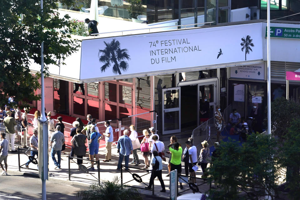 Members of the public walk in front of the Palais des Festival prior to the 74th international film festival, Cannes, southern France, July 5, 2021. The Cannes film festival runs from July 6 - July 17, 2021. (AP Photo/ Brynn Anderson)