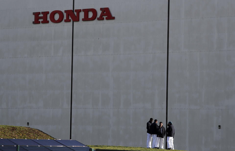 Employees gather as they have a break at the Honda car factory in Swindon, England, Tuesday, Feb. 19, 2019. The Japanese carmaker Honda announced Tuesday that its Swindon car plant in western England, will close with the potential loss of some 3,500 jobs. (AP Photo/Frank Augstein)