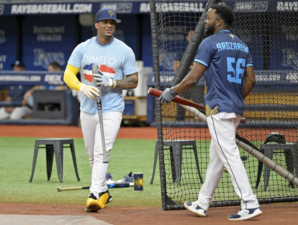 Tampa Bay Rays' Wander Franco, left, and Vidal Brujan, wearing a Arozarena promotional give-away jerseys, switch places during batting practice before a baseball game against the Kansas City Royals Saturday, June 24, 2023, in St. Petersburg, Fla. Franco is expected to return to the lineup after being benched for the previous two games. (AP Photo/Steve Nesius)