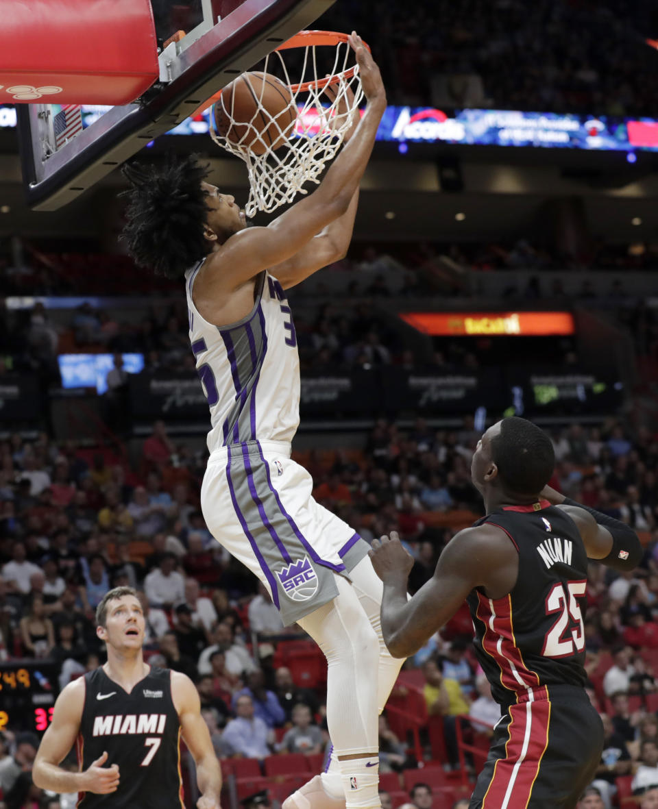 Sacramento Kings forward Marvin Bagley III scores over Miami Heat guard Goran Dragic (7) and guard Kendrick Nunn (25) during the first half of an NBA basketball game, Monday, Jan. 20, 2020, in Miami. (AP Photo/Lynne Sladky)