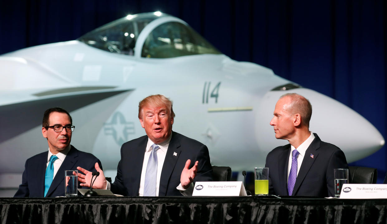 President Donald Trump sits between Treasury Secretary Steve Mnuchin (L) and Boeing Chairman and CEO Dennis Muilenburg (R) during a round table at Boeing in St. Louis, Missouri, U.S. March 14, 2018. Trump griped to donors in the state about a made-up bowling ball test Japan imposes on U.S. cars.