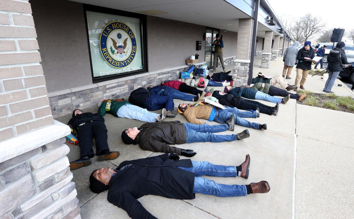 People gather in a "die-in" Wednesday, March 27, 2024, outside the offices of Indiana U.S. Rep. Rudy Yakym, R-2nd, at a prayer vigil for peace by the group Mennonite Action calling on the Congressman to work for a ceasefire in Gaza.