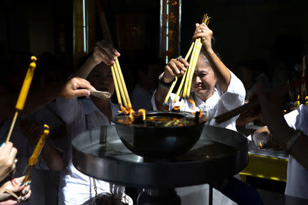 Thai devotees light up their joss sticks at a temple to mark the eve of the vegetarian festival in Bangkok's Chinatown, Thailand, October 19, 2017. Picture taken October 19, 2017. REUTERS/Athit Perawongmetha