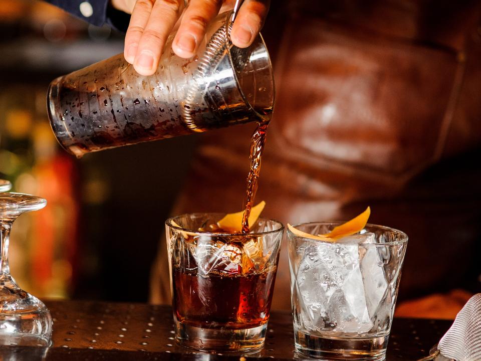 bartender making an old fashioned cocktail at a bar