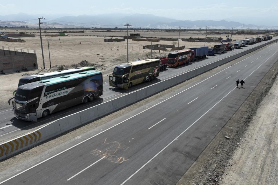 Trucks and buses block the Pan American highway during a strike in Ica, Peru, Tuesday, April 5, 2022. Peru's President Pedro Castillo imposed a curfew on the capital and the country's main port in response to sometimes violent protests over rising prices of fuel and food, requiring people in Lima and Callao to mostly stay in their homes all of Tuesday. (AP Photo/Guadalupe Pardo)