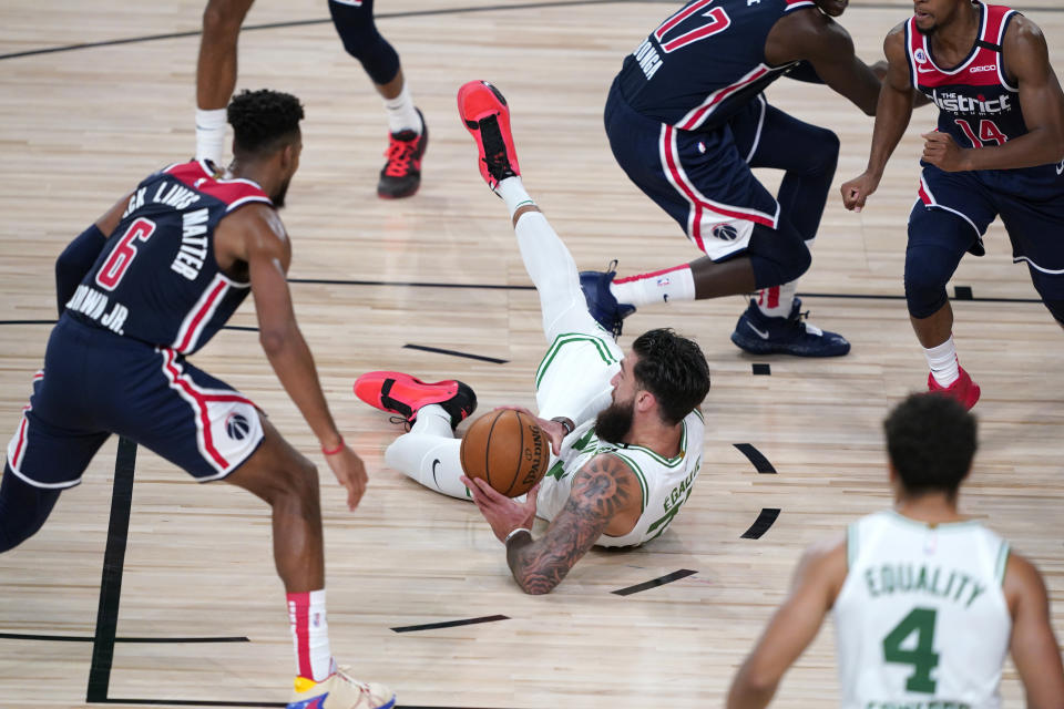 Boston Celtics' Vincent Poirier tries to pass while falling during the second half of an NBA basketball game against the Washington Wizards Thursday, Aug. 13, 2020 in Lake Buena Vista, Fla. (AP Photo/Ashley Landis, Pool)