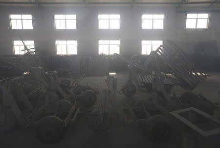 Carts covered by dust are seen deserted inside a building of a closed brick factory on the outskirts of Beijing, China, January 18, 2016. REUTERS/Jason Lee