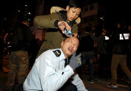 An injured policeman receives treatment after clashes with protesters at Hong Kong's Mongkok shopping district, China early February 9, 2016. REUTERS/Liau Chung-ren