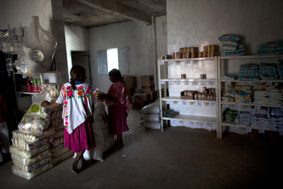 In this Feb. 11, 2014 photo, women shop for supplies at a state-run store in Cochoapa El Grande, Mexico. Much of the food is canned or packaged and shipped from major cities, a practice experts and indigenous advocates called a missed opportunity to help the development of local agriculture. (AP Photo/Dario Lopez-Mills)