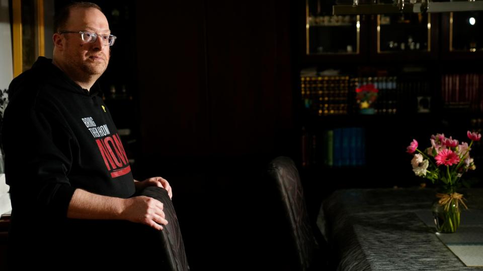 Daniel Rothner poses by an empty chair in his Teaneck home, Wednesday, April 17, 2024. Rothner and his family will keep an empty chair at their table during their Passover seder in honor of those who remain kidnapped since October 7.