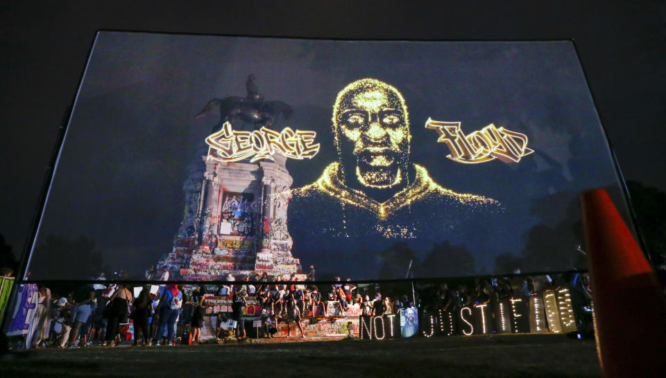 An image of George Floyd is projected on a screen in front of the statue of Confederate General Robert E. Lee on Monument Avenue Tuesday July 28, 2020, in Richmond, Va. Change.org and the George Floyd Foundation officially launched "A Monumental Change: The George Floyd Hologram Memorial Project" in Richmond, the capital of the Confederacy (AP Photo/Steve Helber)