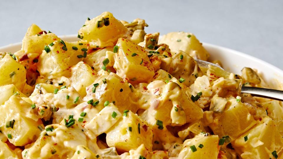 classic potato salad with pickles, onions, and topped with paprika and chives