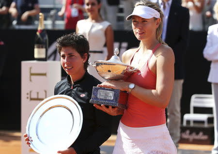 Maria Sharapova of Russia (R) and Carla Suarez Navarro of Spain hold their trophies after their final match at the Rome Open tennis tournament in Rome, Italy, May 17, 2015. REUTERS/Stefano Rellandini