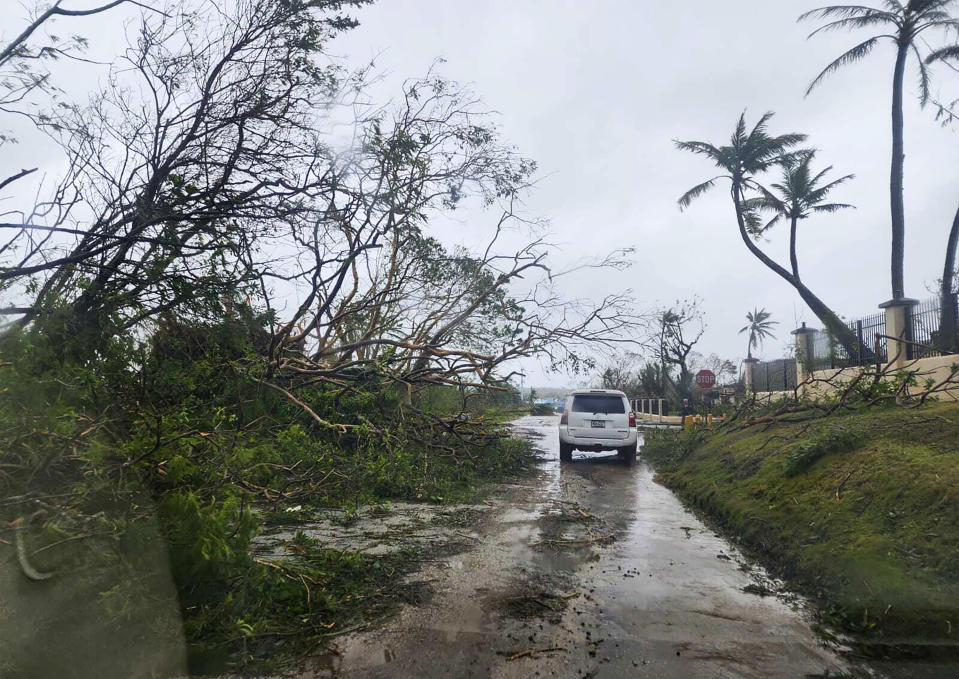 In this photo provided by Chris Leavitt, downed trees litter a street Thursday, May 25, 2023, in Yigo, Guam, after Typhoon Mawar passed over the island. (Chris Leavitt via AP)