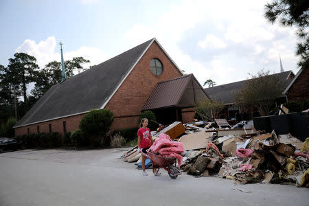 A volunteer helps clean up the damage at a Lutheran church in Dickinson, Texas. REUTERS/Carlos Barria