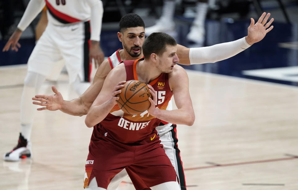 Denver Nuggets center Nikola Jokic looks to pass the ball as Portland Trail Blazers center Enes Kanter defends during the second half of an NBA basketball game Tuesday, Feb. 23, 2021, in Denver. (AP Photo/David Zalubowski)