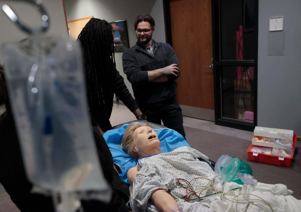 Paramedic students Autumn Anderson, left, and Stephen Henderson talk during a break in assessing the vital signs on a mannequin during scenario training at the Medstar offices in Clinton Township on Wednesday, Nov. 1, 2023.