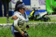 <p>Women walk away from the site of a series of explosions at fireworks warehouses in Tultepec, central Mexico, on July 5, 2018. – At least 17 people were killed, including rescue workers who died saving others’ lives, officials said. The initial explosion occurred around 9:30 am (1430 GMT), then spread to other warehouses just as police and firefighters began attending to the first victims. (Photo: Pedro Pardo/AFP/Getty Images) </p>