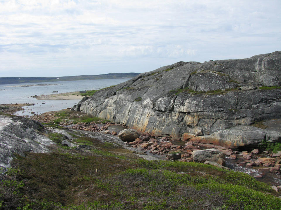 Outcrops of 2.7 billion-year-old granite. The rocks that were recycled to form this granite likely formed about 4.3 billion years ago and then persisted as oceanic crust for more than a billion years before becoming submerged and partially melting. They then reformed into the rocks still present today. <cite>Jonathan O'Neil</cite>