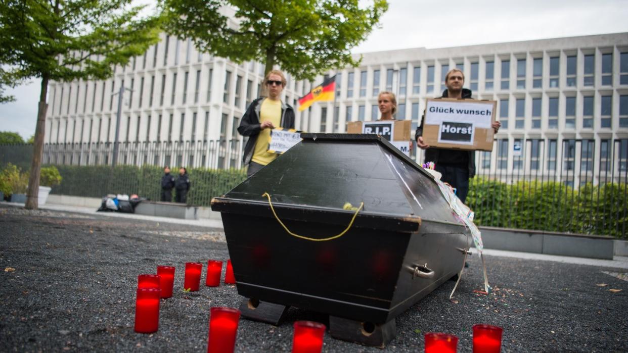 Menschen gedenken vor dem Bundesinnenministerium mit einem symbolischen Sarg Jamal Nasser M., der sich in Kabul das Leben genommen hat. Foto: Arne Immanuel Bänsch