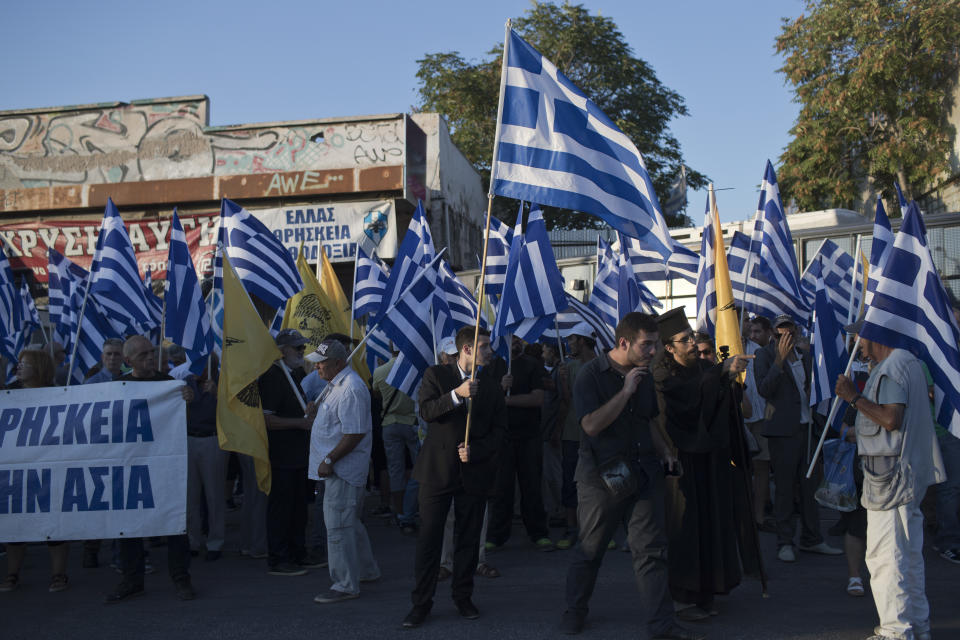 Supporters of Greece's extreme right Golden Dawn party wave Greek flags during a rally against the construction of a mosque, in Athens, Wednesday, Sept. 5, 2018. (AP Photo/Petros Giannakouris)