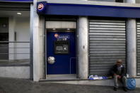 A man sells napkins by an Eurobank ATM that was emptied by people withdrawing cash, in Athens, Greece, June 27, 2015. REUTERS/Yannis Behrakis