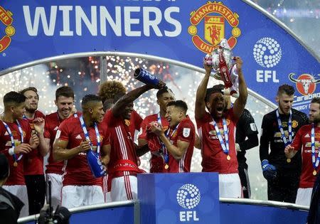 Britain Soccer Football - Southampton v Manchester United - EFL Cup Final - Wembley Stadium - 26/2/17 Manchester United's Eric Bailly pours champagne over Jesse Lingard as they celebrate with team mates and trophy after winning the EFL Cup Final Reuters / Hannah McKay