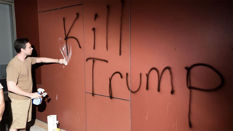 A member of the public tries to scrub away 'Kill Trump' graffiti as demonstrators riot in California. Photo: Reuters