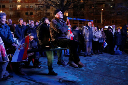 People watch on a screen the news conference of Serbian President Aleksandar Vucic and Russian President Vladimir Putin in front of the St Sava temple in Belgrade, Serbia, January 17, 2019. REUTERS/Bernadett Szabo