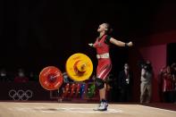 Windy Cantica Aisah of Indonesia celebrates after a lift as she competes in the women's 49kg weightlifting event, at the 2020 Summer Olympics, Saturday, July 24, 2021, in Tokyo, Japan. (AP Photo/Luca Bruno)