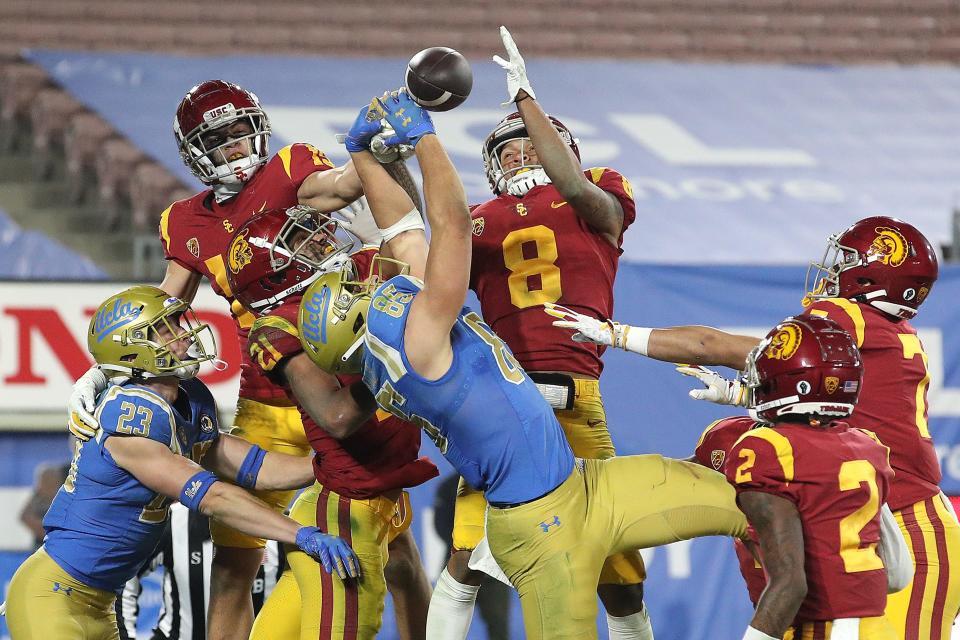 Greg Dulcich (85) and Chase Cota (23) of UCLA are unable to catch a last-second pass as Chris Steele (8), Olaijah Griffin (2), Chase Williams (7) and Isaiah Pola-Mao (21) of USC defend during the second half of a game at the Rose Bowl on Dec. 12, 2020 in Pasadena, Calif.