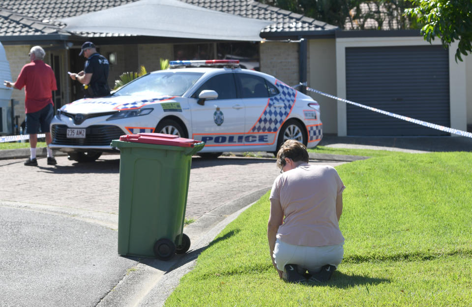 Local resident Louise Christy is seen kneeling in mourning outside the home of murder victim Kelly Wilkinson on the Gold Coast. Source: AAP